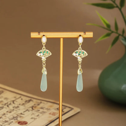 Fan earrings with light green drops and chains on gold hanger, green vase and scroll