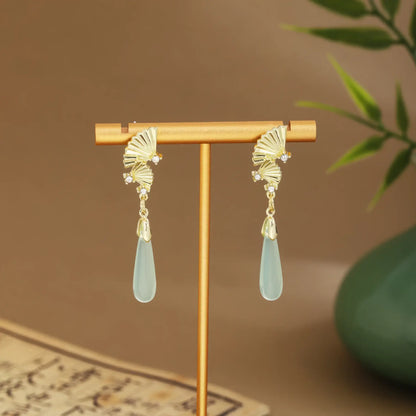 Butterfly - shaped earrings with light green drops on gold hanger, green vase and scroll