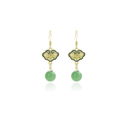 Pair of green fan - shaped earrings with green drops on white background