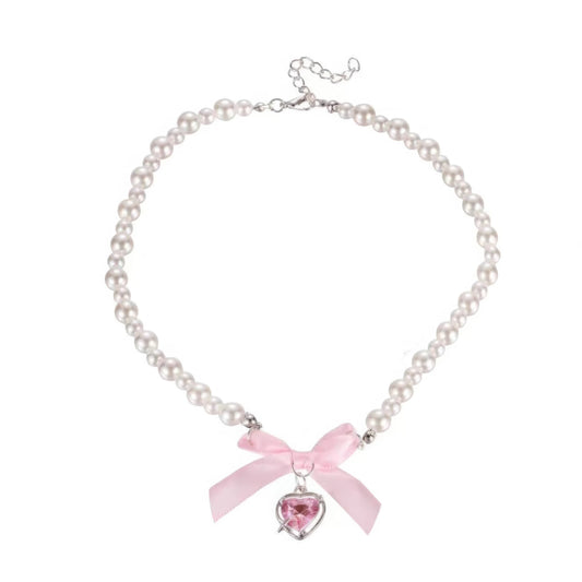 Heart bow necklace, isolated on white background, featuring pink ribbon and pearl chain