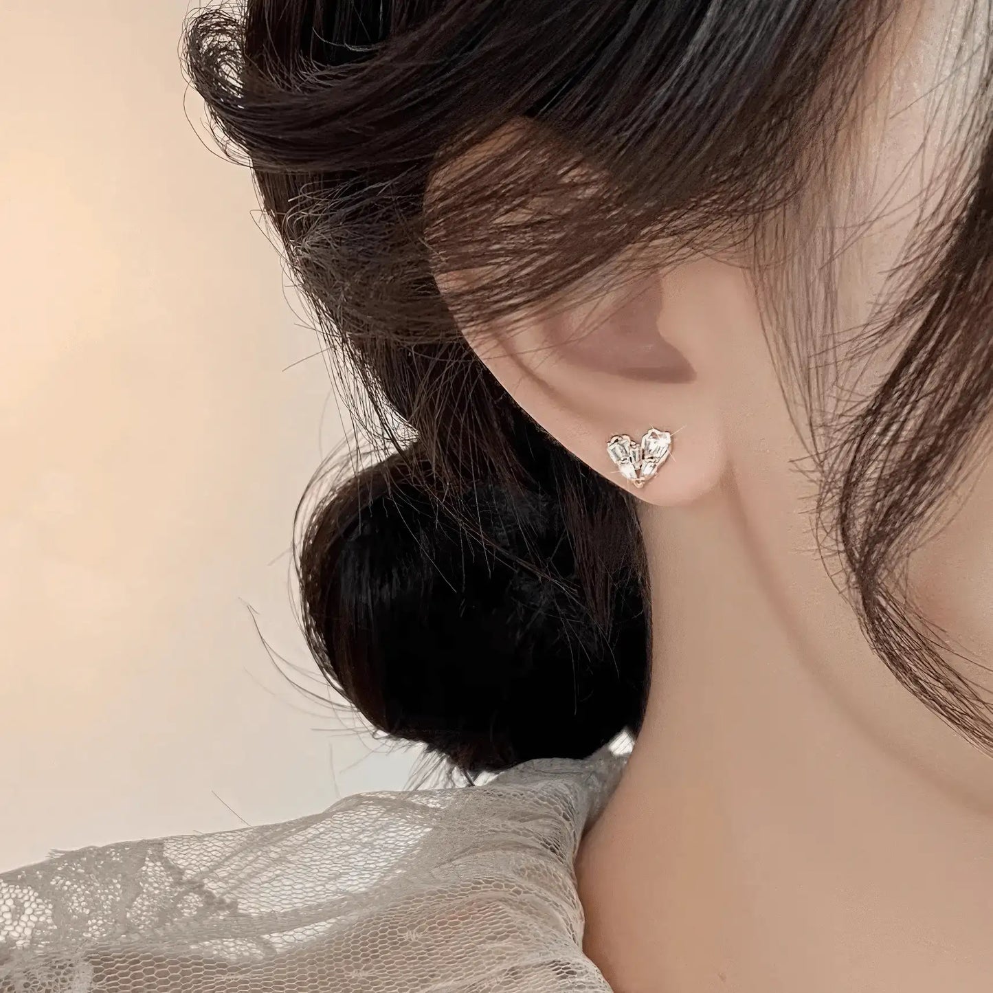 Side view of heart - shaped earrings worn on ear, emphasizing style