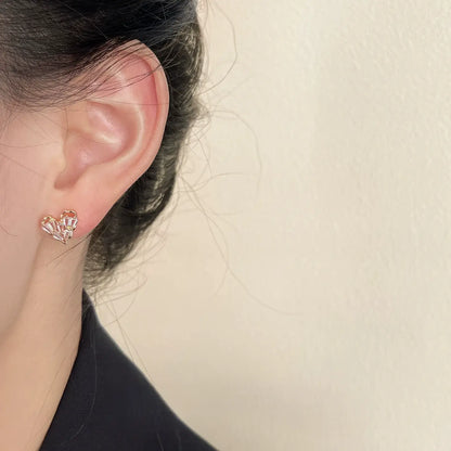Tiny heart - shaped earrings worn on ear, showcasing understated elegance