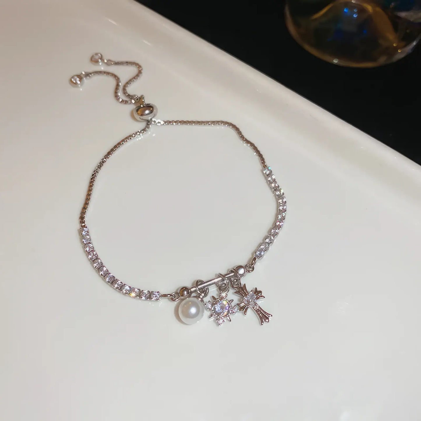 Iris cross bracelet with pearl, silver - tone, displayed on white pad