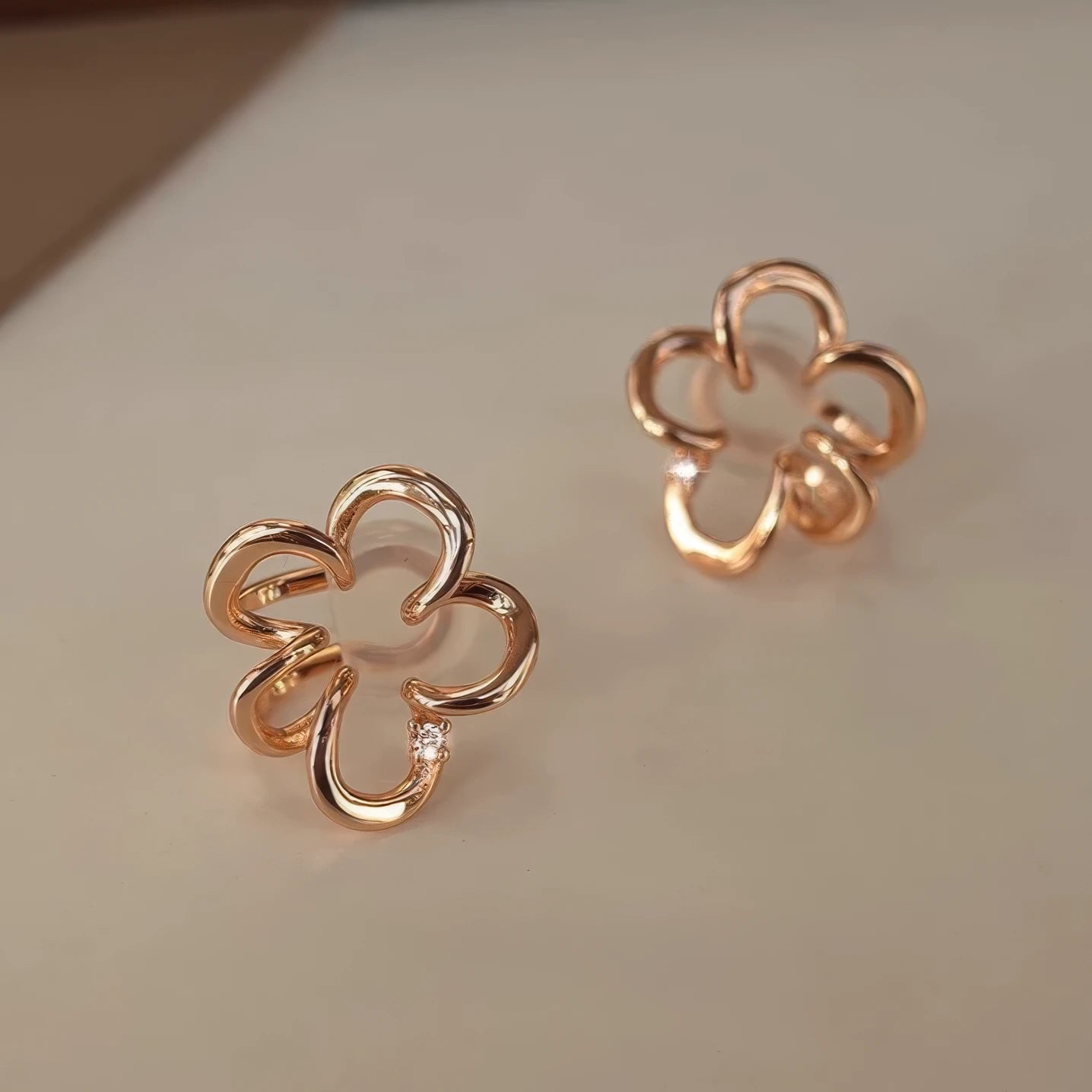 Gold irregular flower ear clips, isolated on a light - colored surface, emphasizing the elegant design