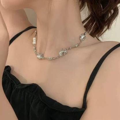 Irregular shaped pearl necklace worn with a black camisole, showcasing elegance
