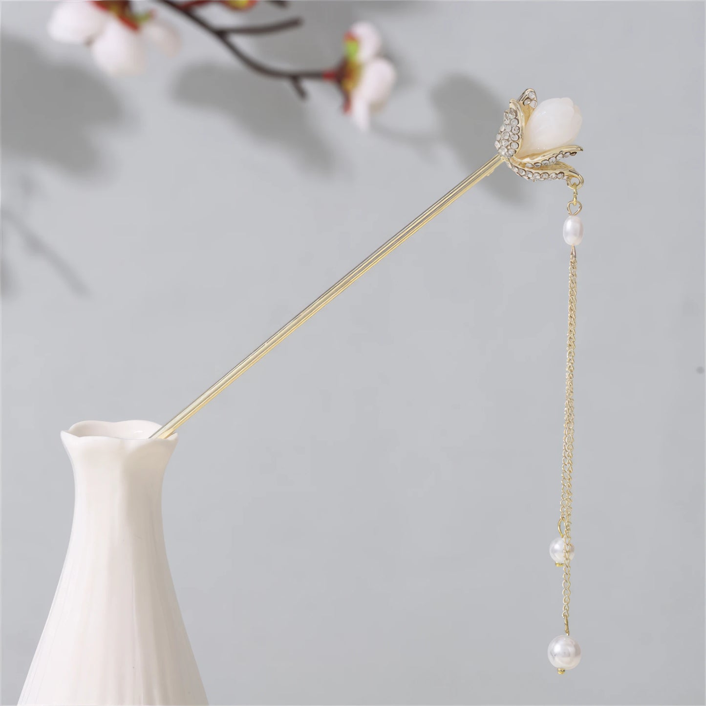 Jianjianjiao hairpin 6, gold rod with pearl and flowers, in white vase against light gray background with plum blossoms