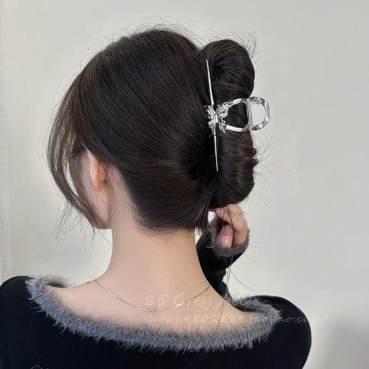 A different angle of the liquid metal butterfly shark clip worn in an updo hairstyle