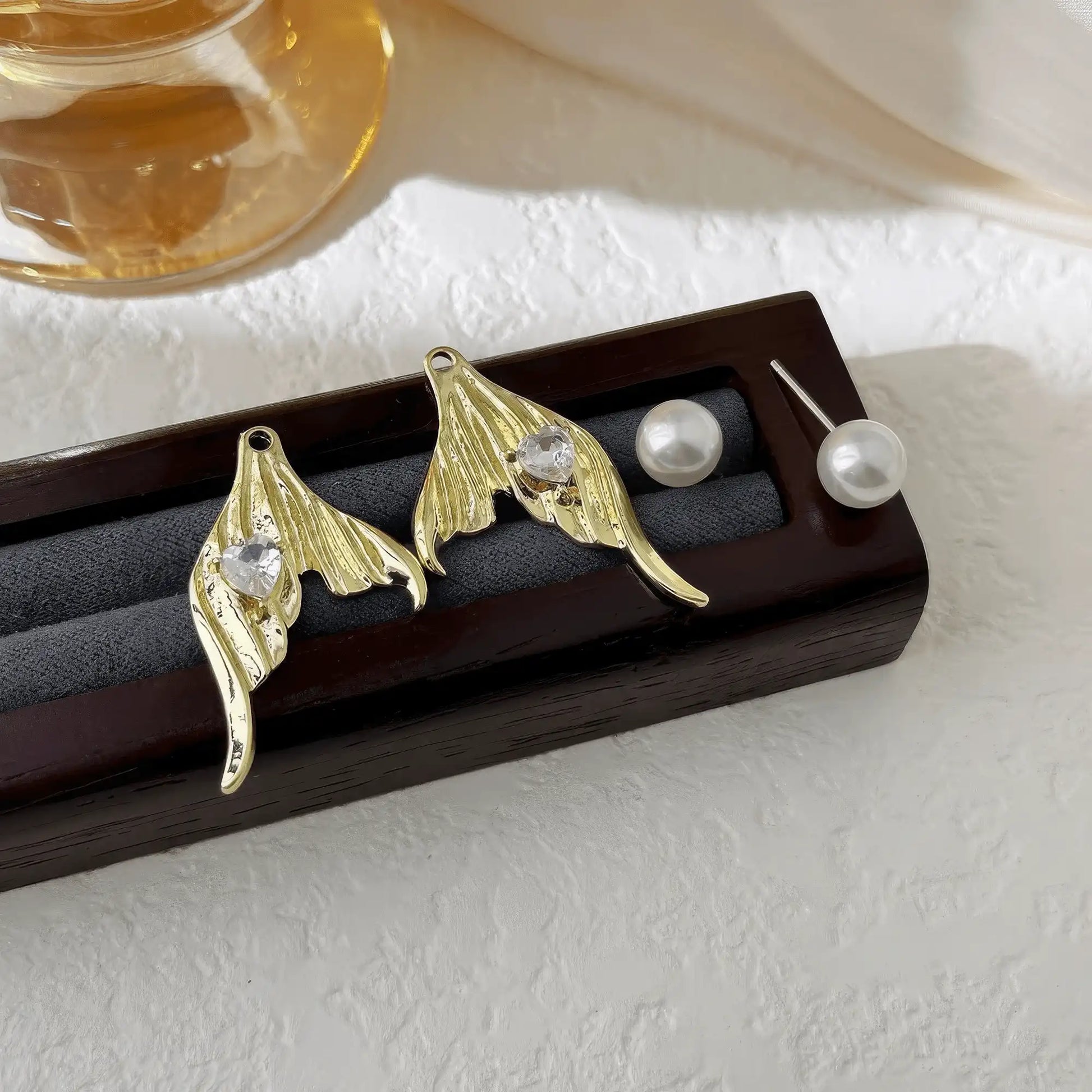 Gold mermaid tail heart diamond pearl earrings on display stand, clear details
