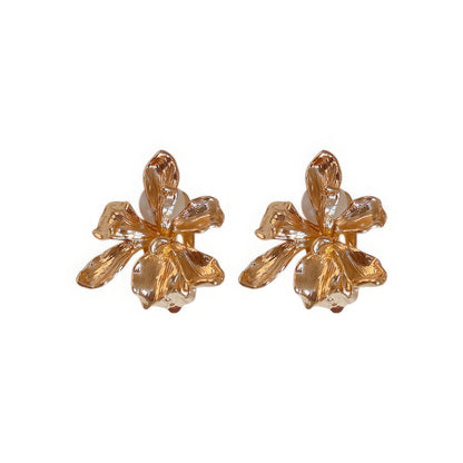 Gold metal flower ear clips isolated on a white background