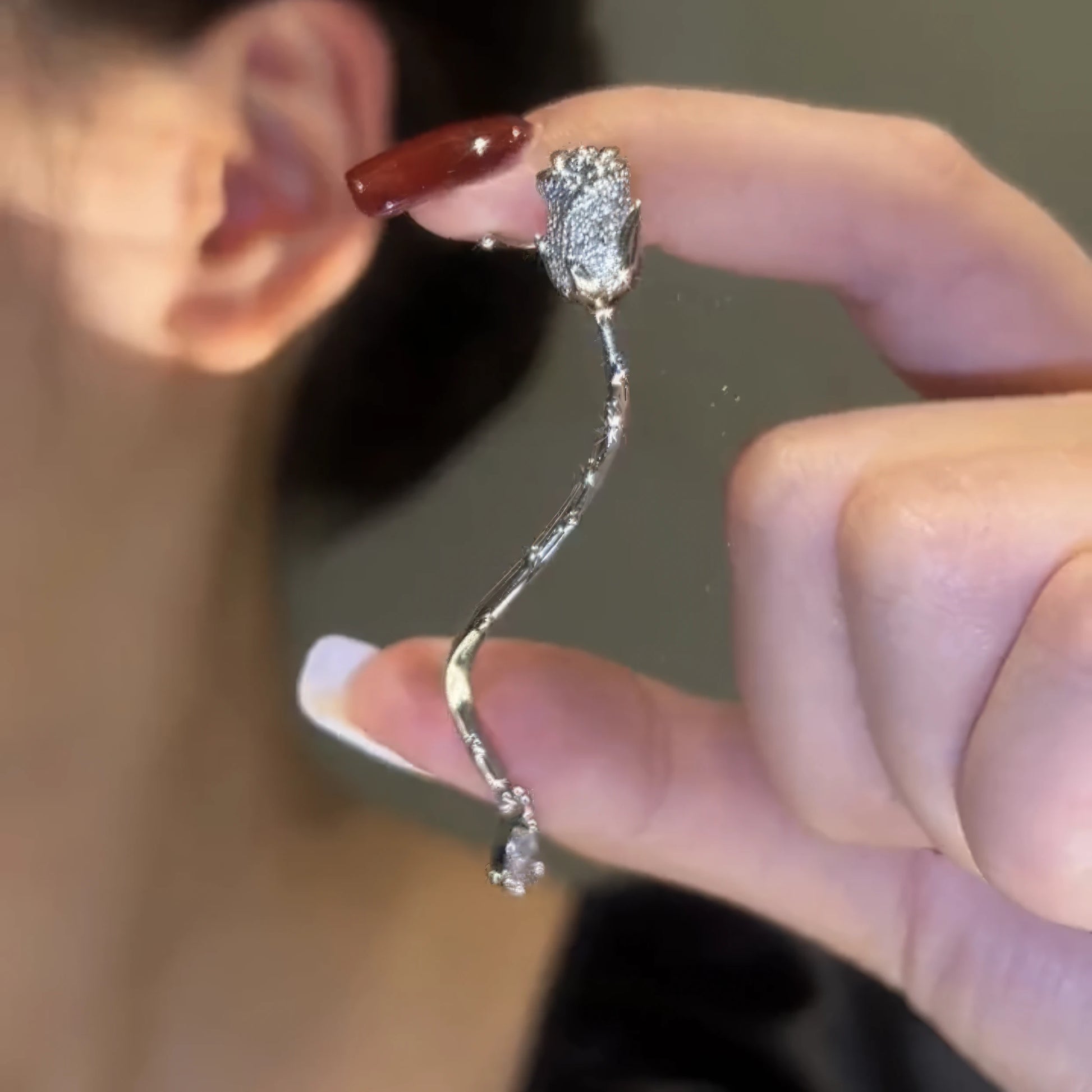 Long multi - layer butterfly ear cuff, held near ear, dangling design