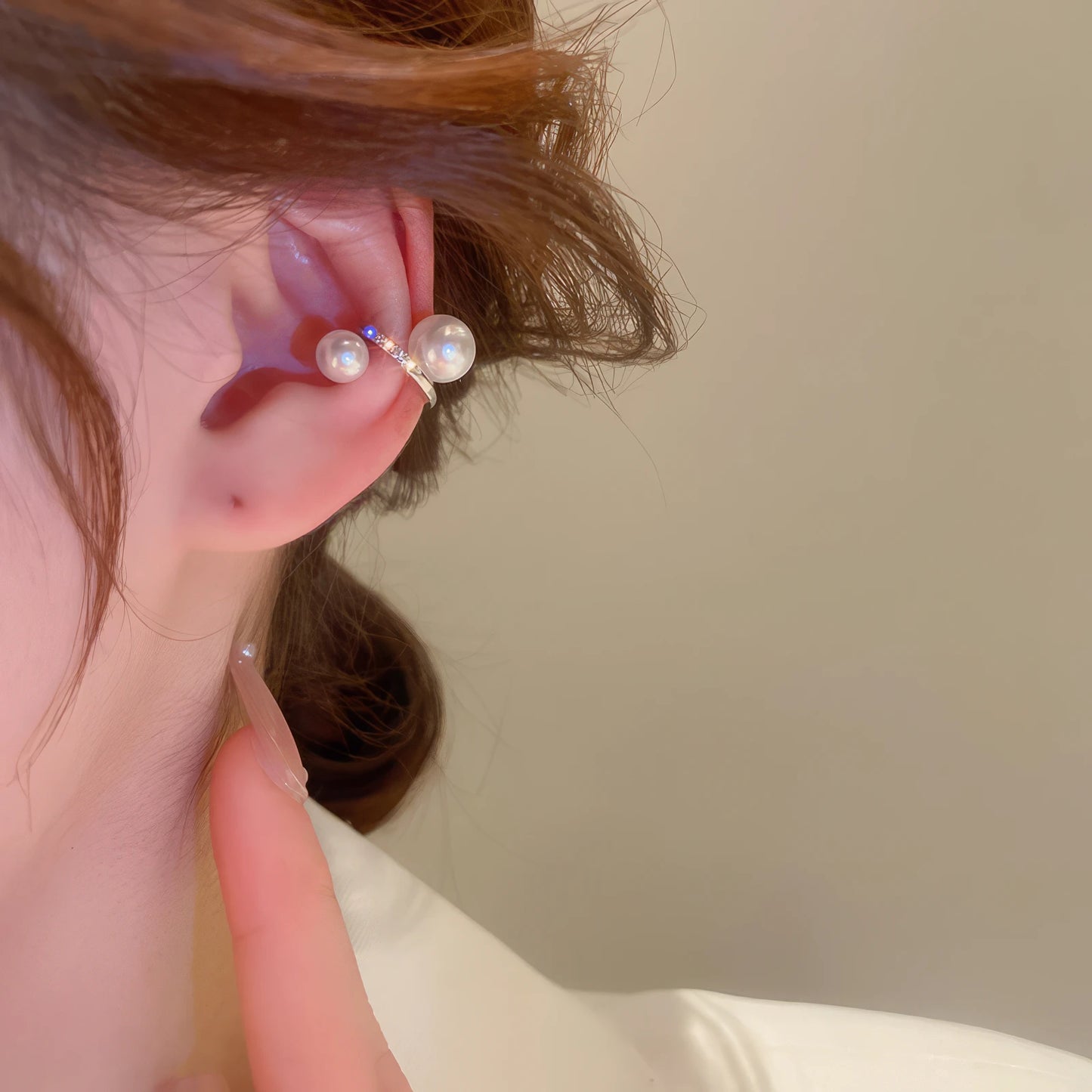 Multi - layer butterfly ear cuff with pearl accents, worn on ear