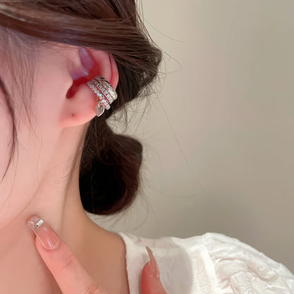 Multi - layer butterfly ear cuff on ear, with white clothing backdrop