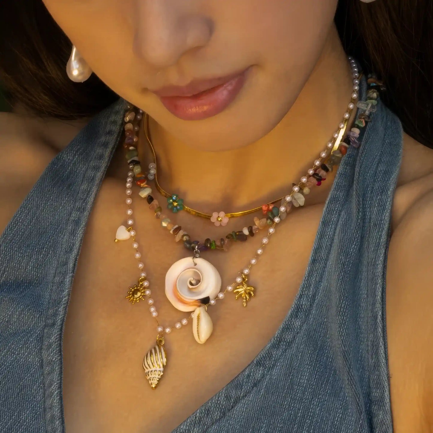 Natural shell beaded pendant necklace worn, emphasizing design with blue top