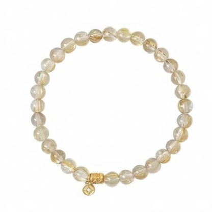 Single - strand natural stone citrine rutilated quartz bracelet, isolated on white background