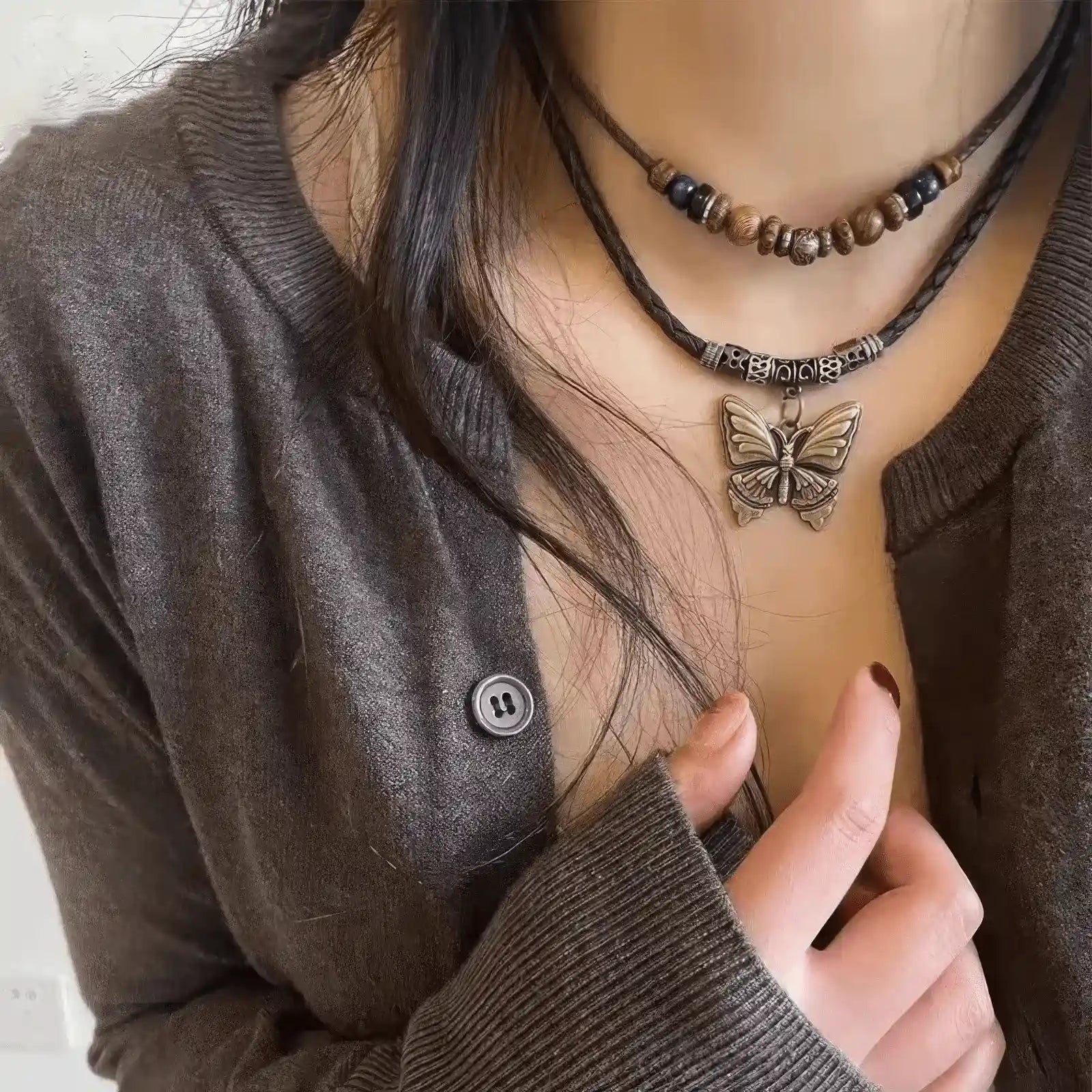 New Chinese ethnic style braided pendant necklace worn, featuring a butterfly pendant, complementing a gray cardigan, highlighting elegance