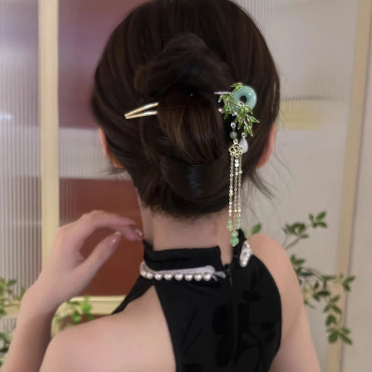 A woman in a black Chinese-style sleeveless dress with a pearl necklace, wearing the peace buckle hairpin in an updo hairstyle, front view