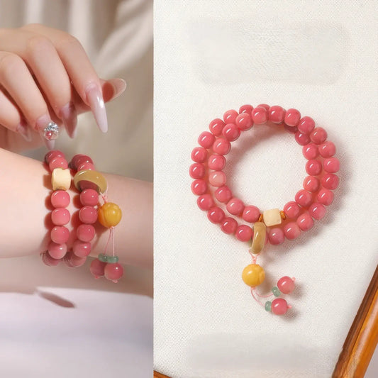 Double - strand peach pink white jade bodhi bracelet worn on hand, highlighting bracelet details