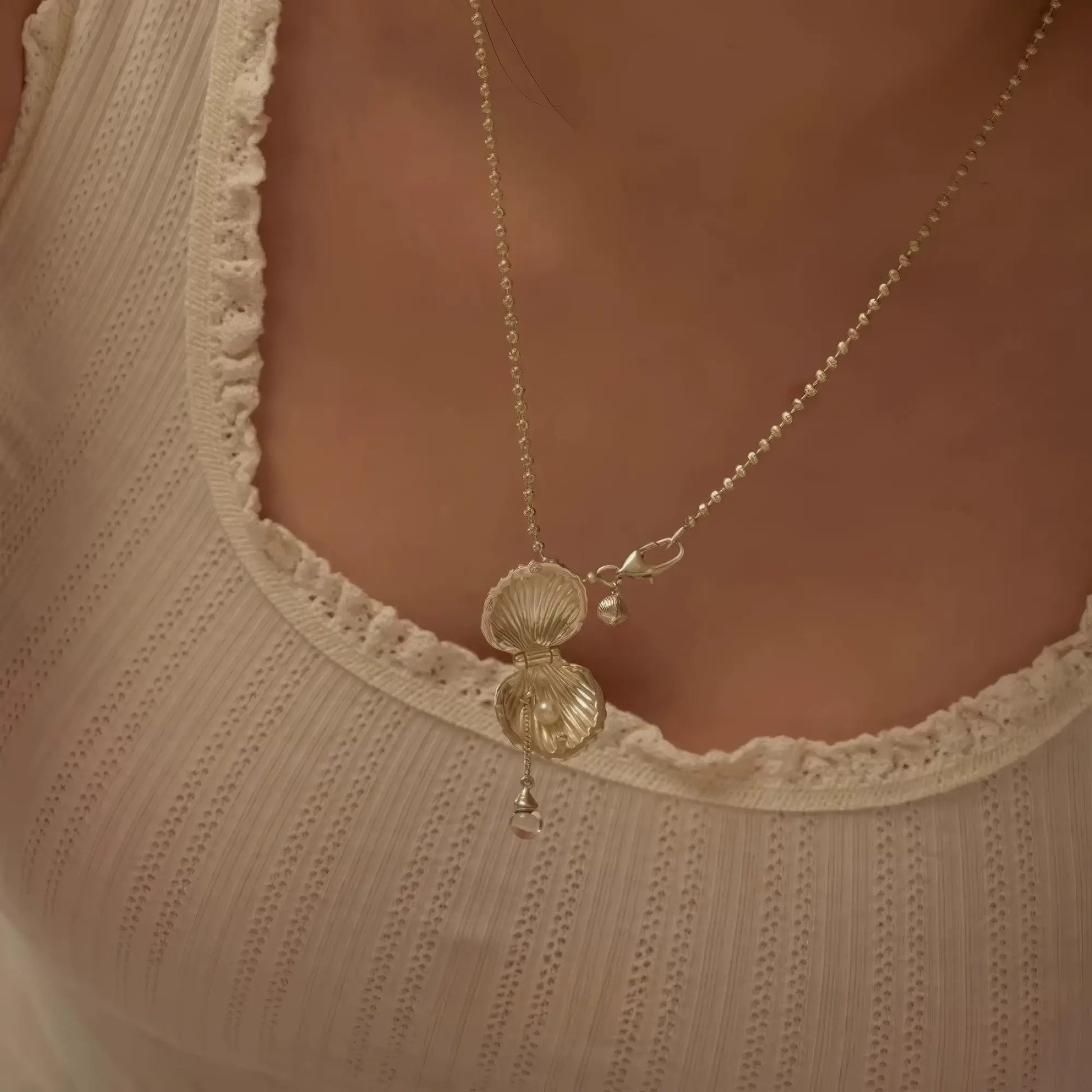 Gold pearl shell pendant necklace worn, showcasing elegance