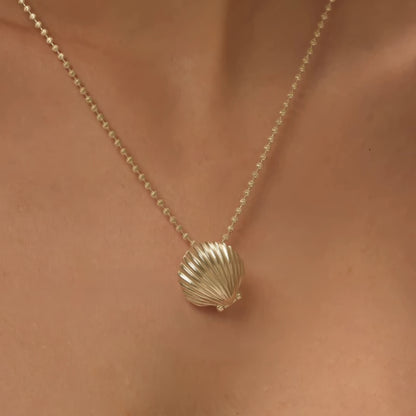 Gold pearl shell pendant necklace worn, highlighting style