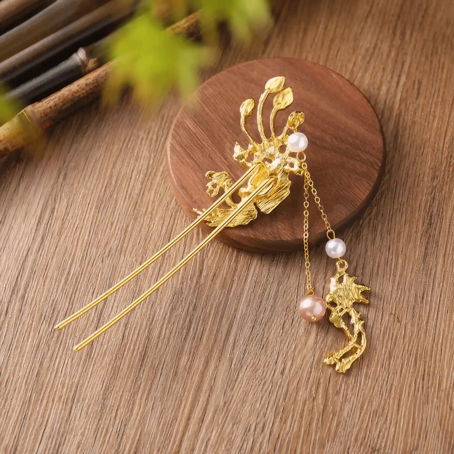 An angled view of the phoenix travel hairpin, on a bamboo background