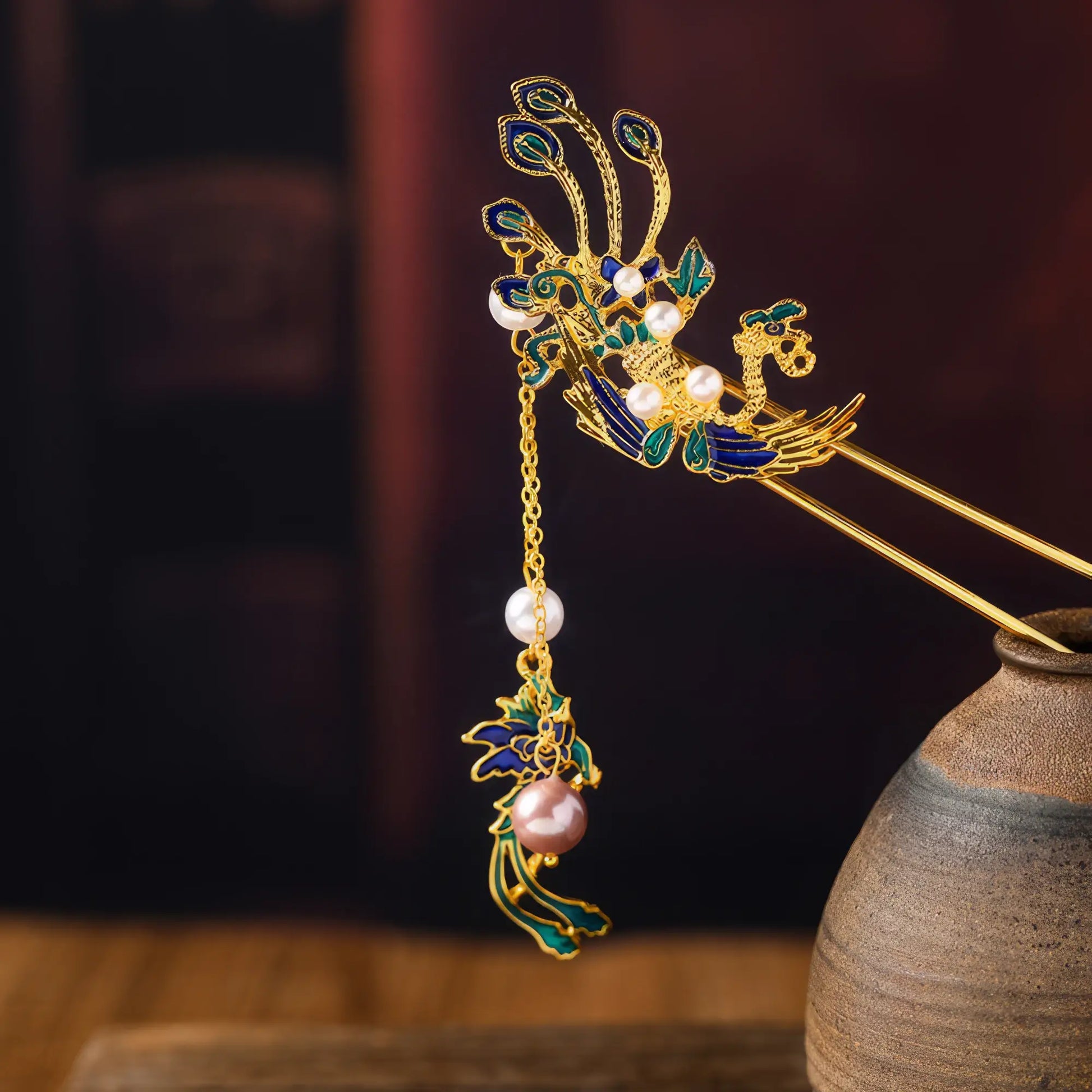 Close - up of the three - dimensional decoration on the top of the phoenix travel hairpin, on an antique ware background