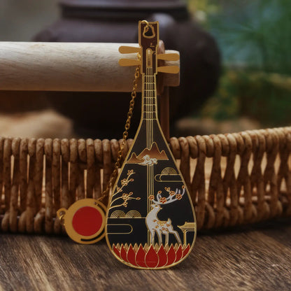 Pipa - shaped bookmark adorned with a black color and deer motif, having a small hanging chain, displayed on a woven basket backdrop.