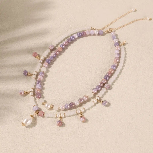 Overall view of purple bead and pearl necklace with dangling elements