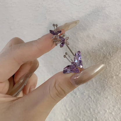 Purple butterfly zircon ear cuff, held in hand with long nails