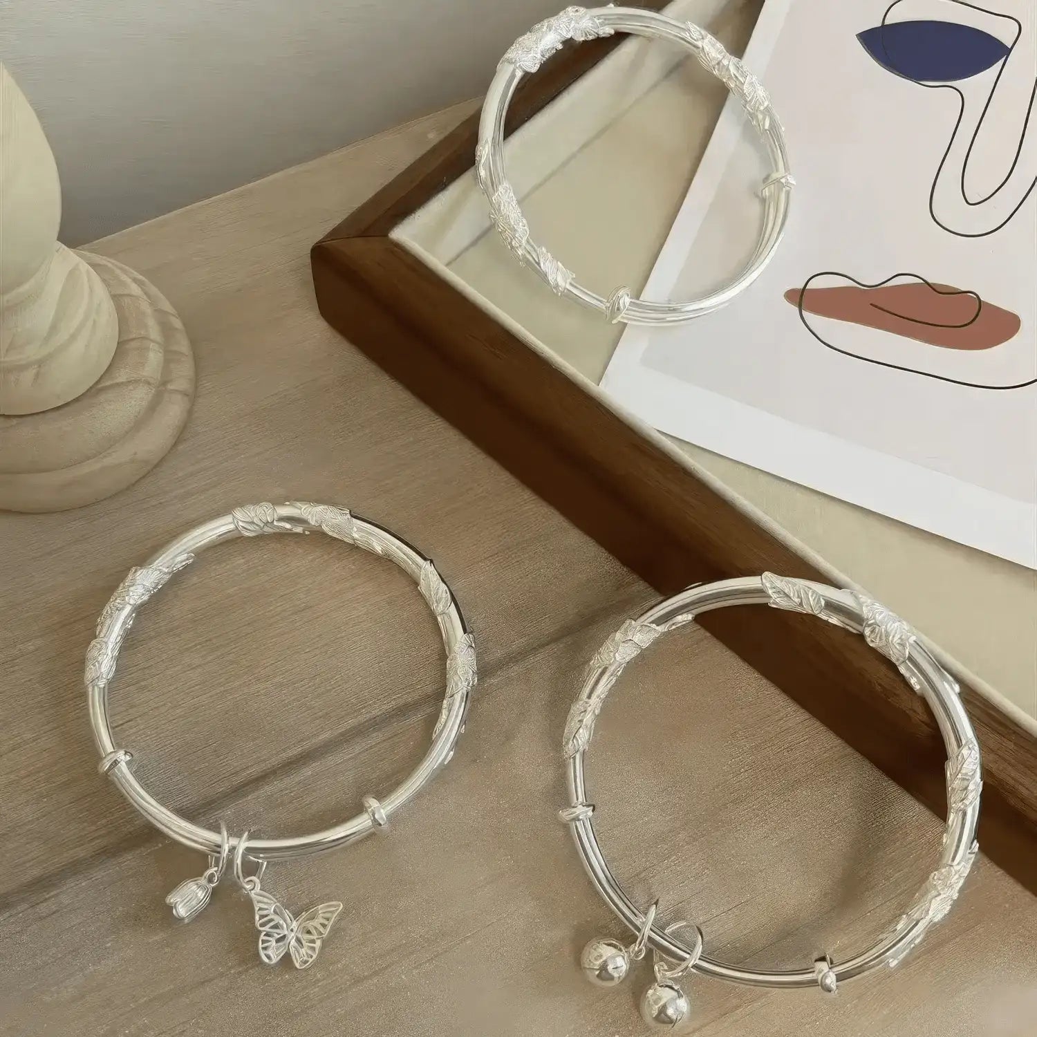 Push - pull flower hanging bell bangles displayed on surface, emphasizing set