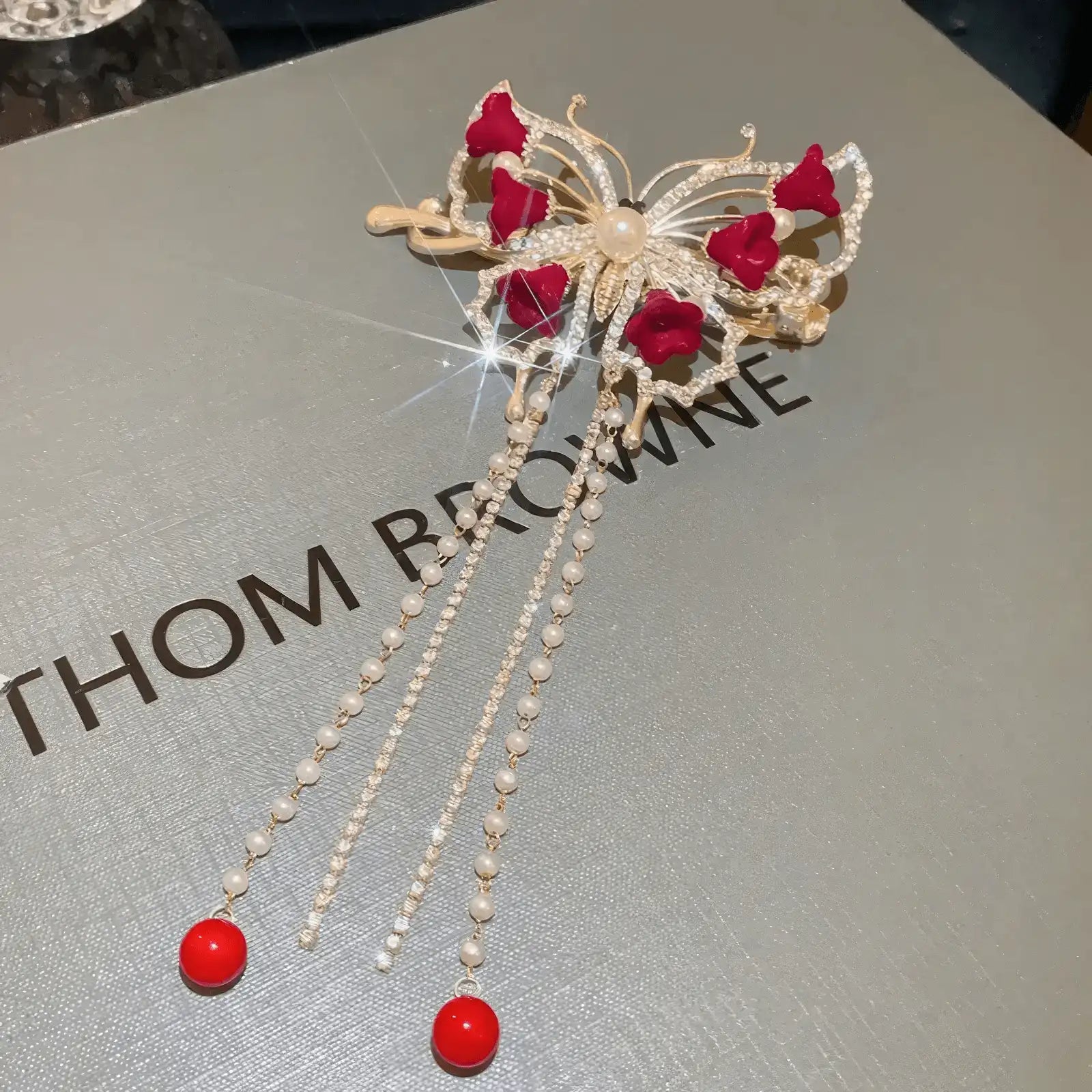 Red flower butterfly hair clip with gold base on box