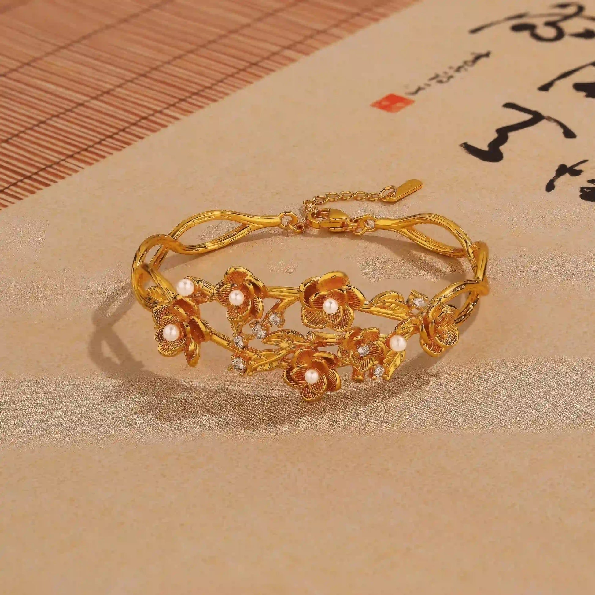 Gold rose pearl bracelet placed on paper with calligraphy, showcasing elegant design