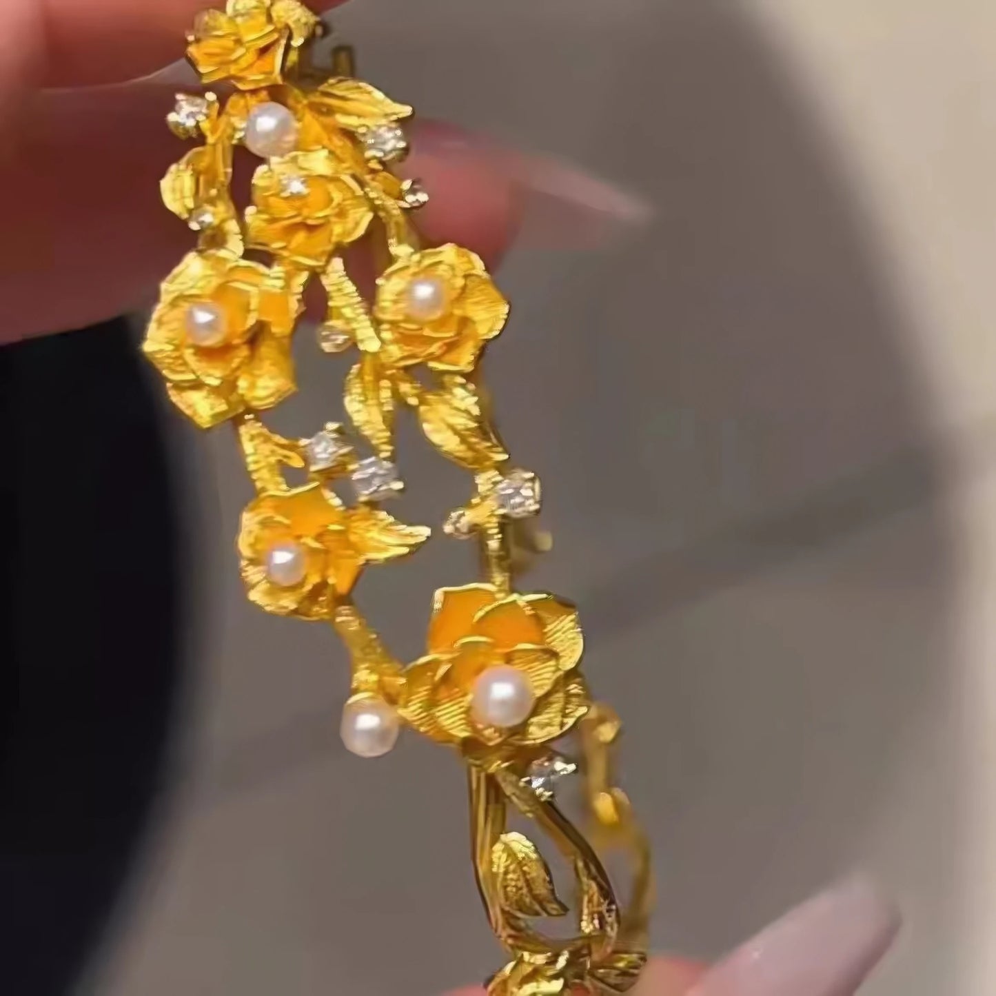 Close - up of gold rose pearl bracelet, emphasizing floral and pearl details