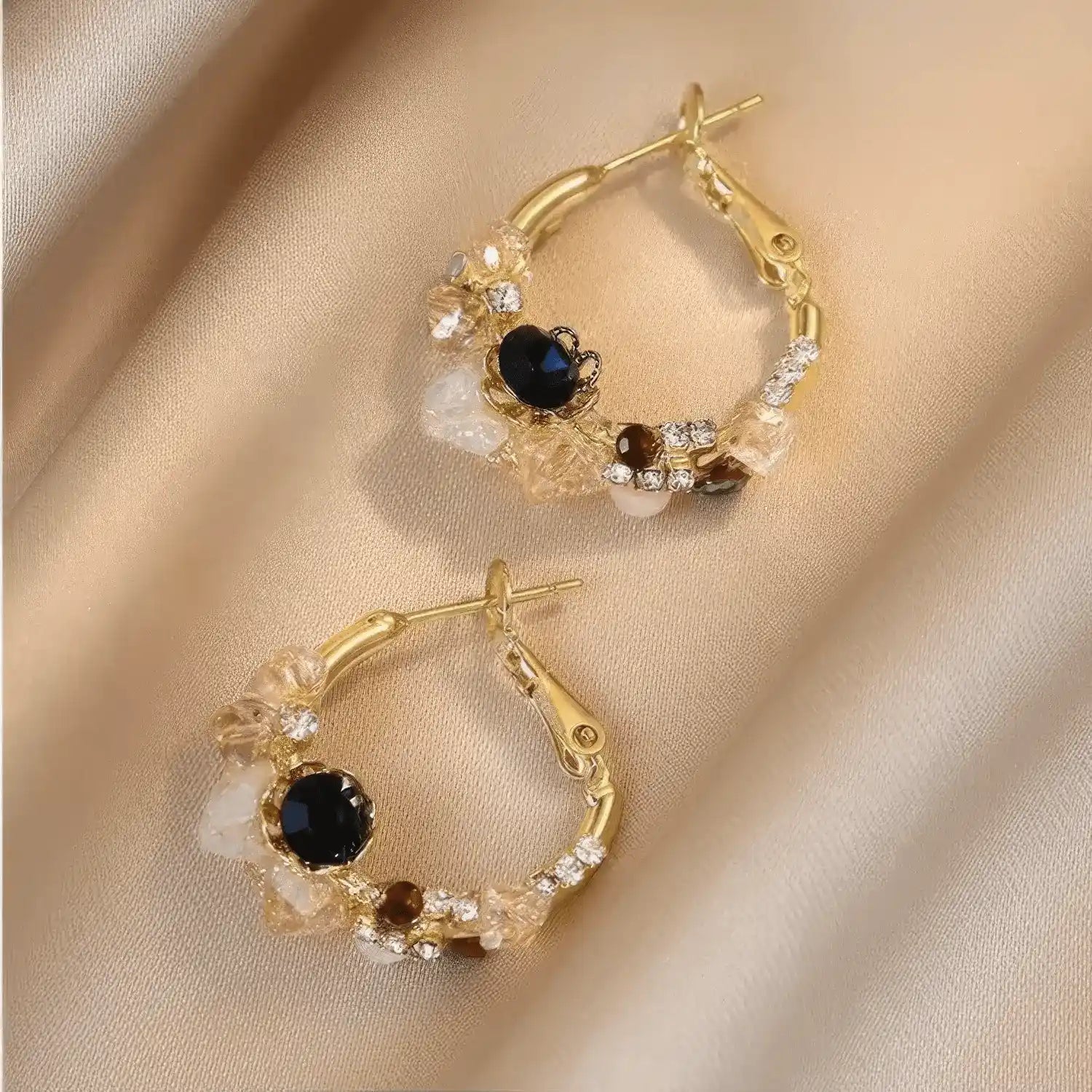 Sea blue champagne wreath earrings displayed on fabric, emphasizing design