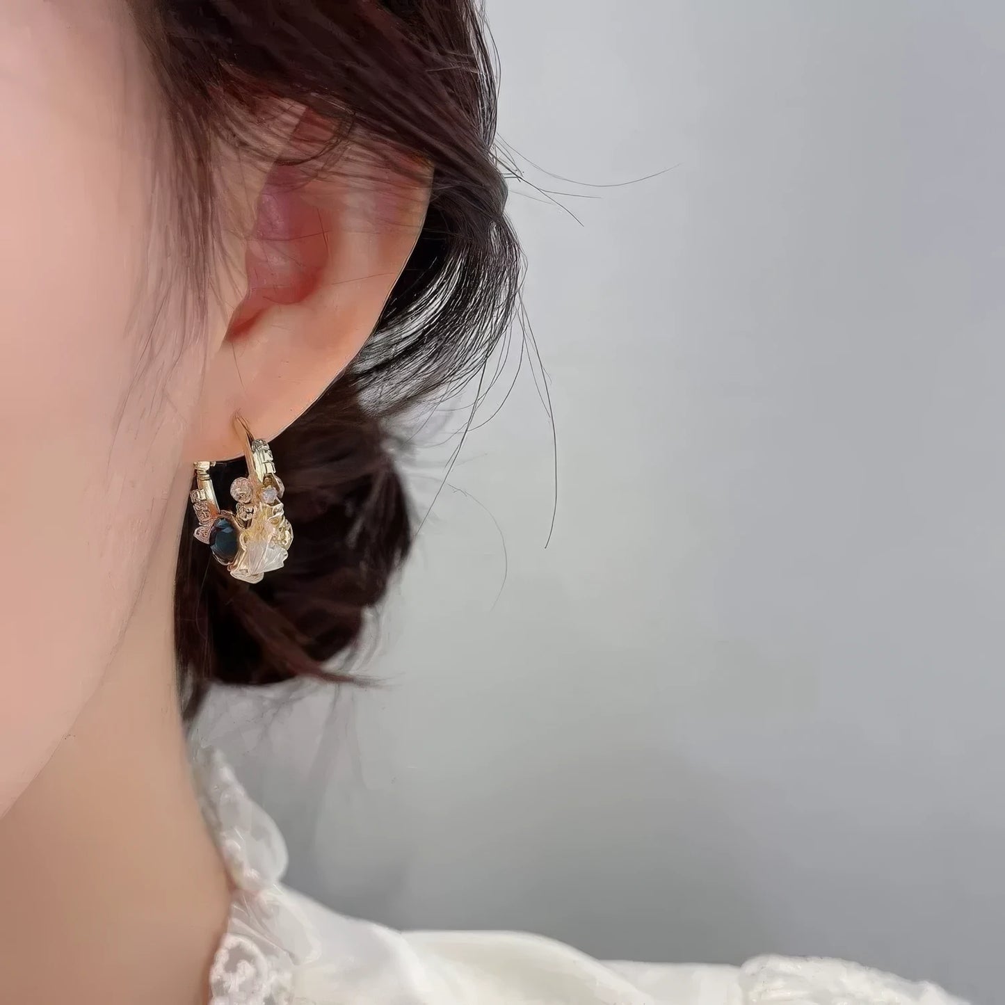 Sea blue champagne wreath earring worn on ear, emphasizing elegance