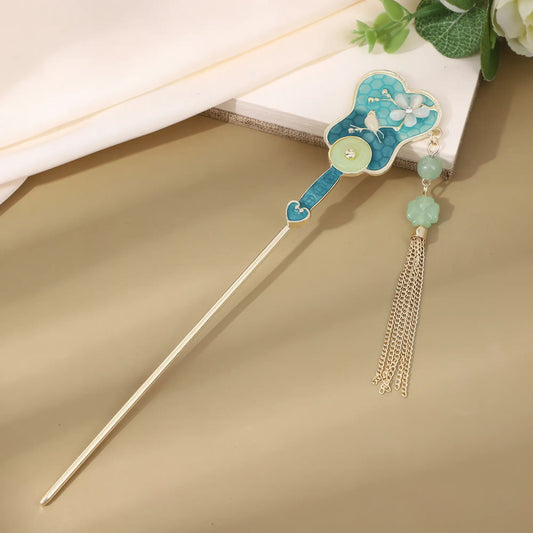 Shuiweipei hairpin with blue floral and gold tassel, brown background with white fabric and flowers