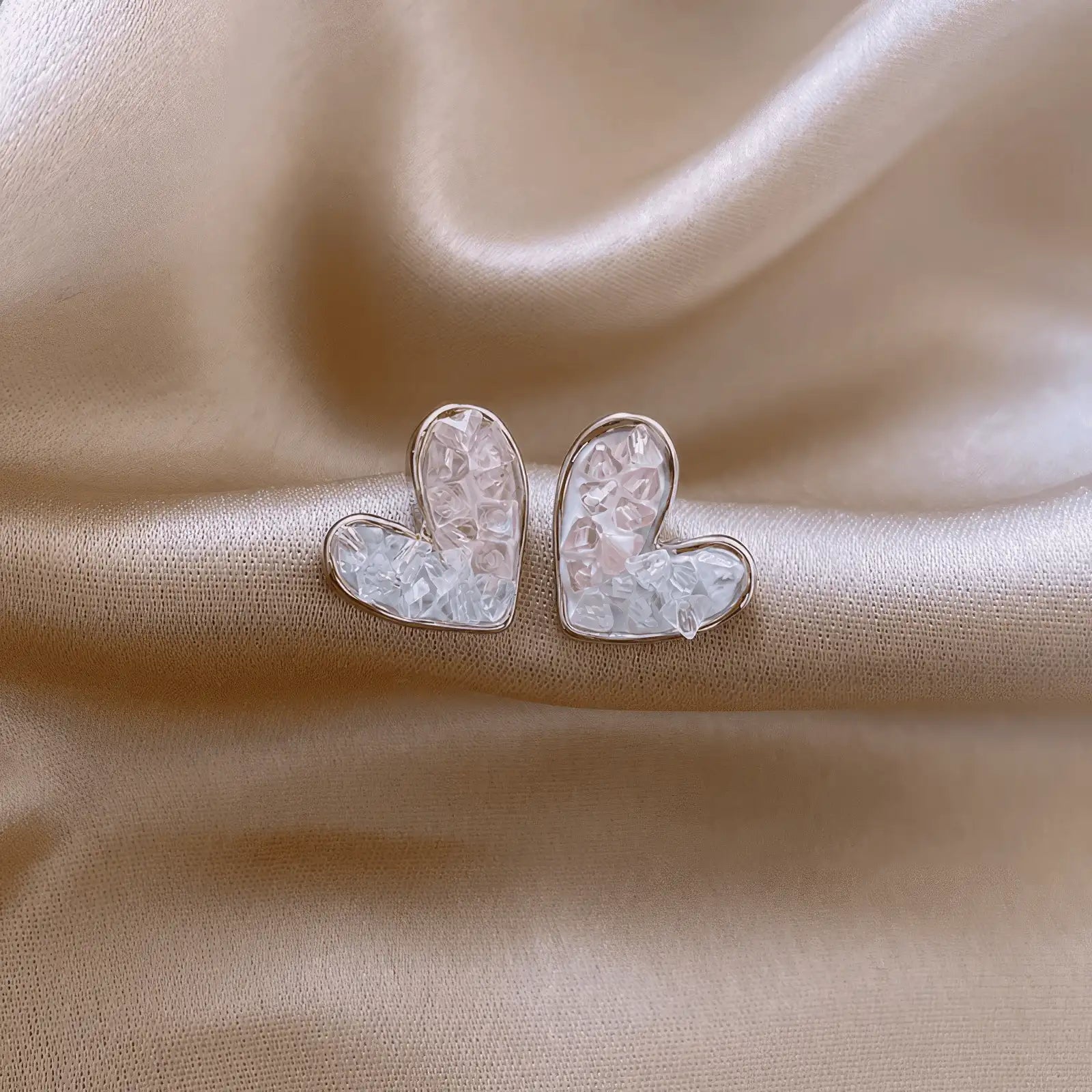 Silver crystal heart - shaped earrings on satin