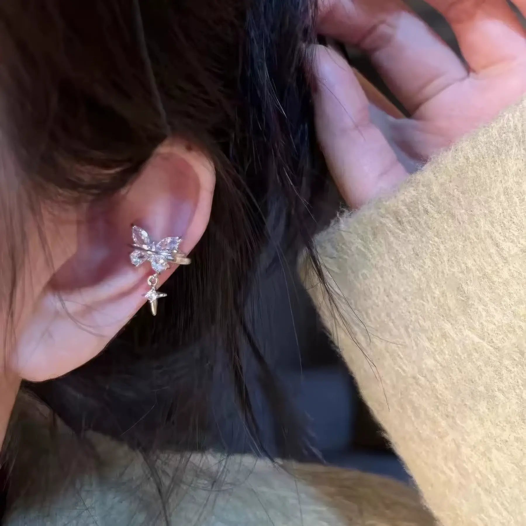 Star butterfly ear clip being adjusted, highlighting the detailed craftsmanship