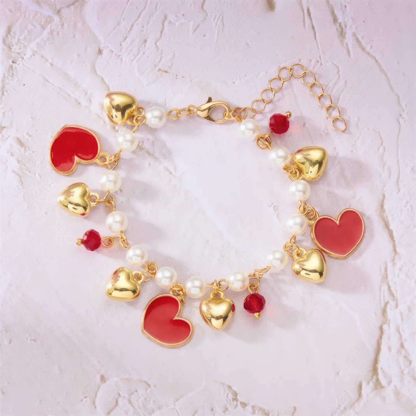 Layout of strawberry cherry heart pearl bracelet with heart charms on a light surface