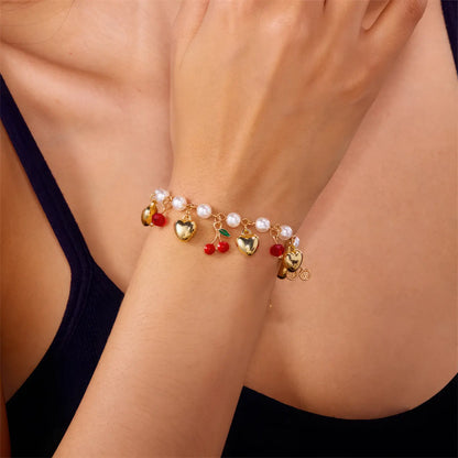 Another view of strawberry cherry heart pearl bracelet worn on a wrist