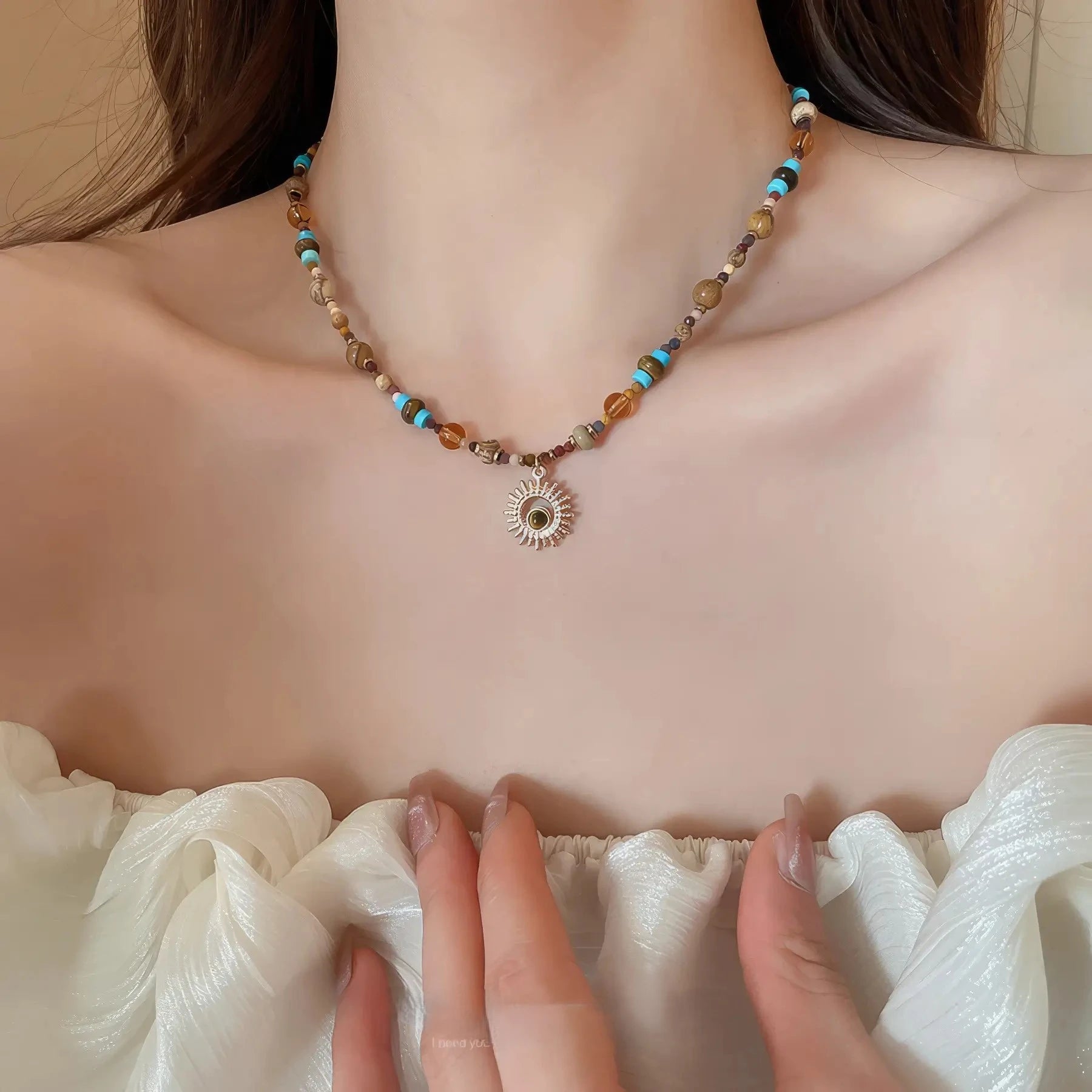 Sunflower beaded necklace, multi - color stones, gold - tone pendant, worn on off - shoulder top