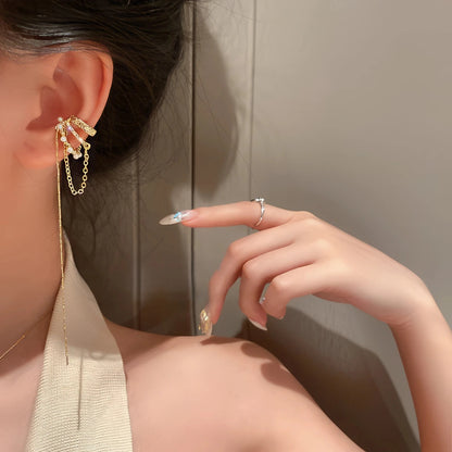 Tassel diamond earrings worn on ear, hand showing ring