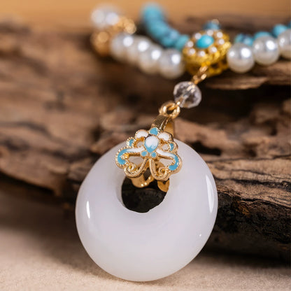 Detail of turquoise peace buckle necklace with pearls, displayed on wooden board