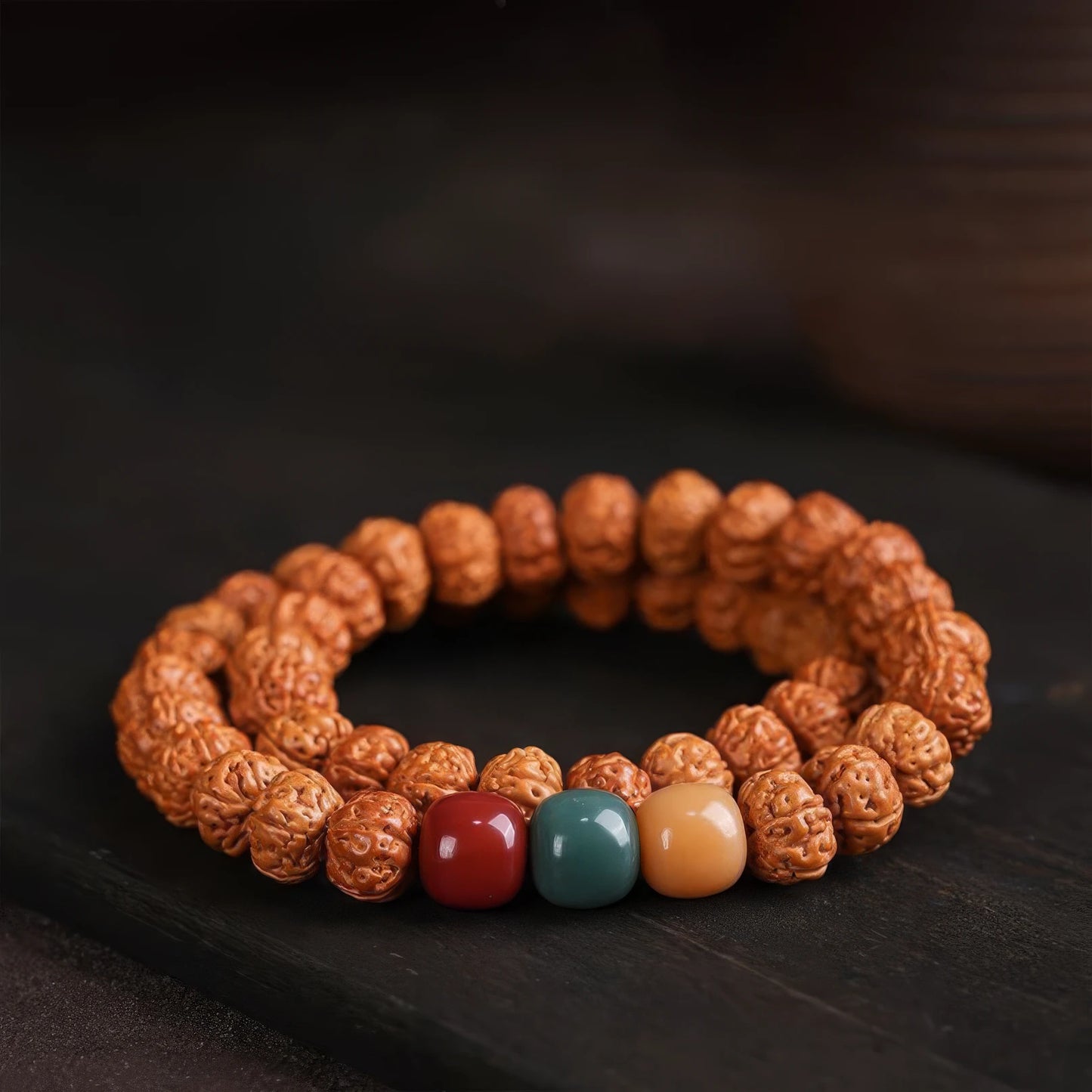 Vajra bodhi bracelet with multi - colored accent beads, displayed on dark background