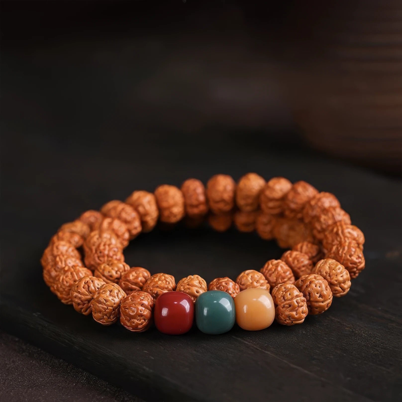 Vajra bodhi bracelet with multi - colored accent beads, displayed on dark background
