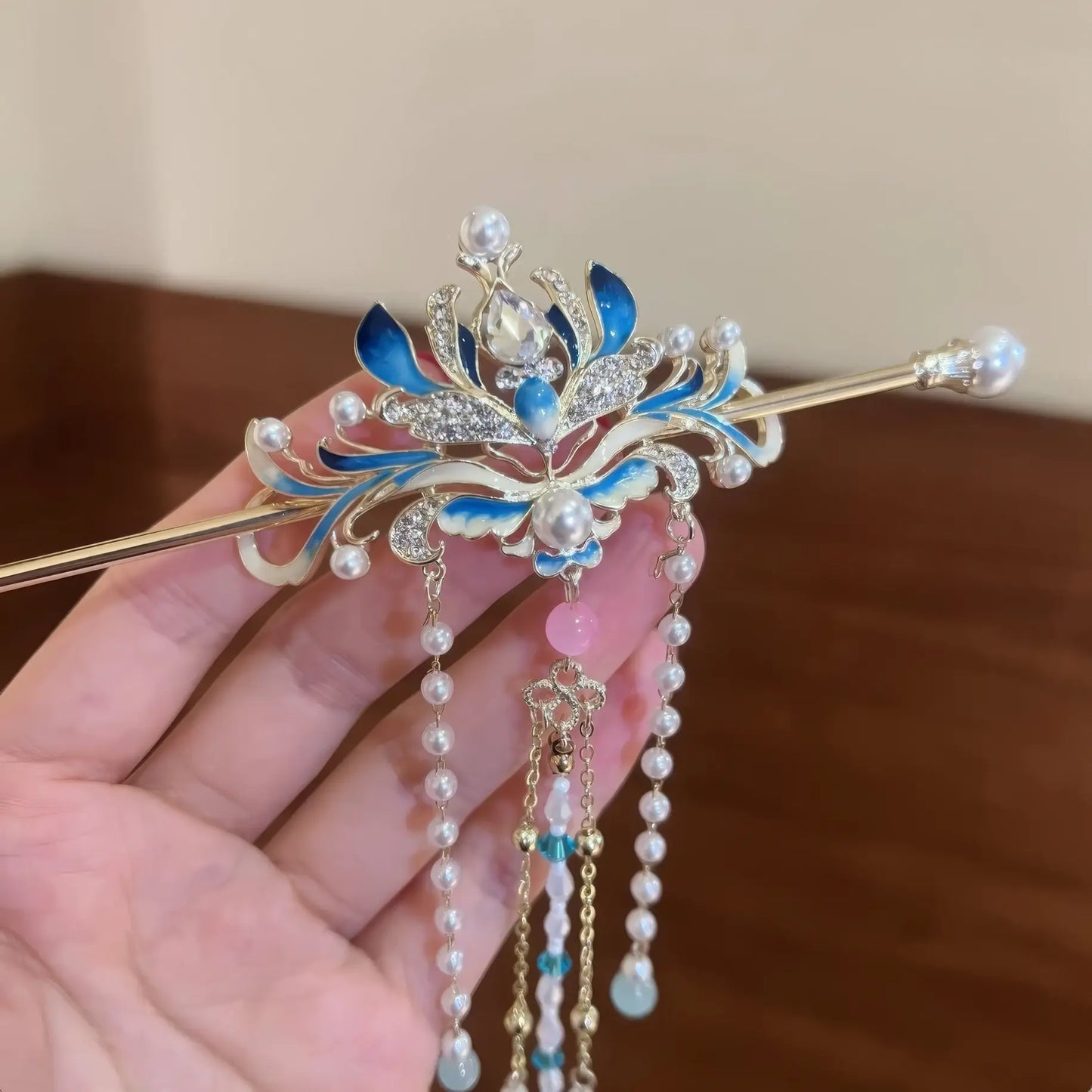 Close-up of the enamel blue lotus hairpin, showing tassel details.