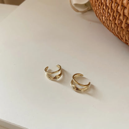 Gold vintage geometric high - end ear cuffs, isolated on white background, showcasing the layered design