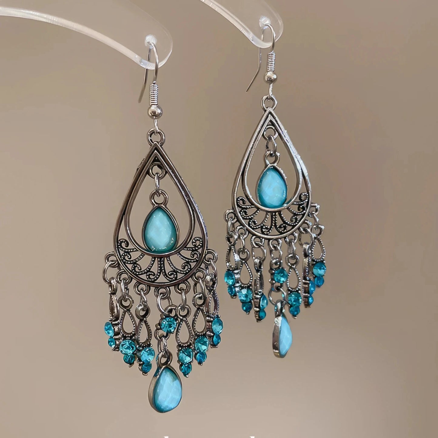 Water drop tassel earrings, blue stones with silver - tone filigree, isolated on white background