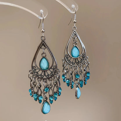 Water drop tassel earrings, blue stones with silver - tone filigree, isolated on white background