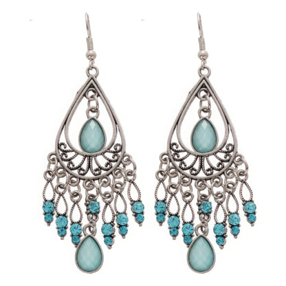 Water drop tassel earrings, blue stones with silver - tone filigree, isolated on white background (close - up)