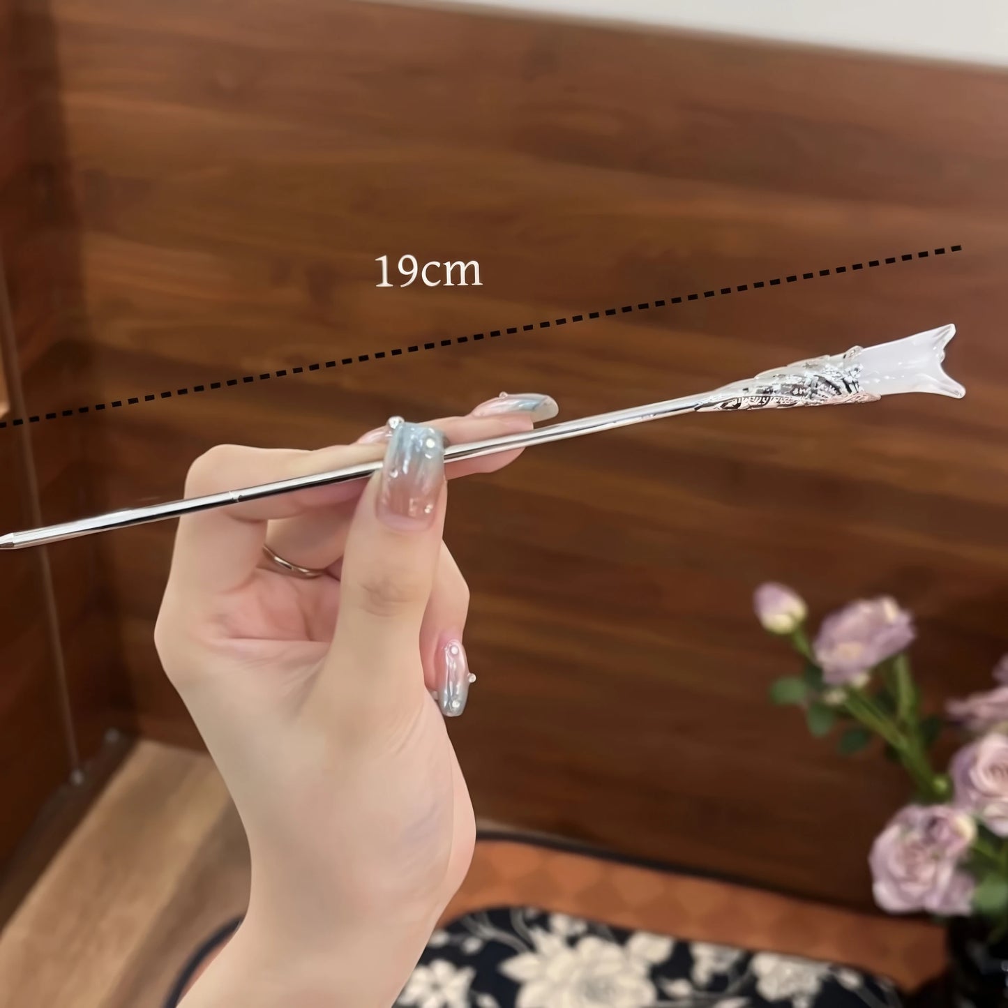 Hand holding white magnolia hair pin, size 19cm, showcasing length